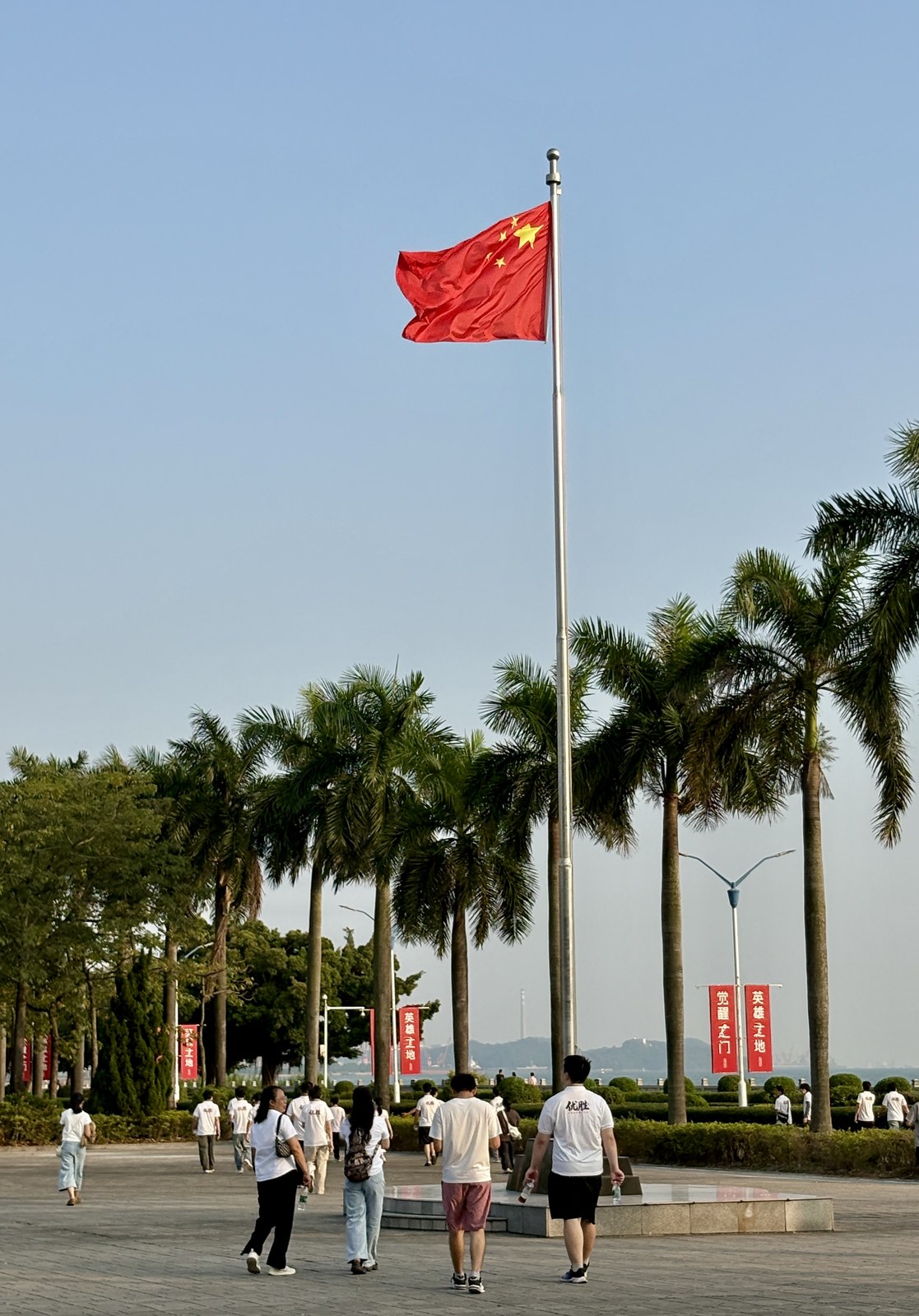 虎门海战博物馆海边广场上飘扬的五星红旗与英雄土地、觉醒之门主题道旗
